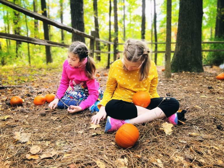 Amelia and Makenzie Kahn playing outdoors surrounded by trees and nature